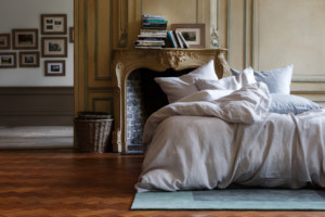 Ein luxuriöses Schlafzimmer mit Kamin und einem Bett mit Christian Fischbacher Bettwäsche