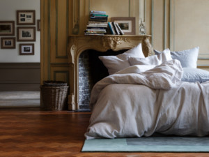 Ein luxuriöses Schlafzimmer mit Kamin und einem Bett mit Christian Fischbacher Bettwäsche